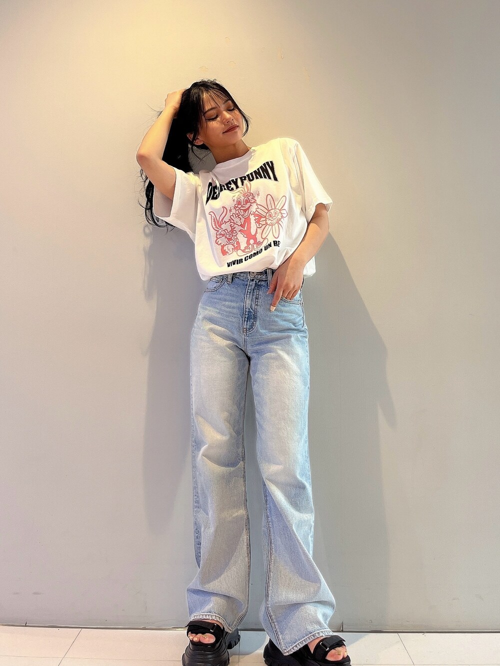 ホワイト系のTシャツ/カットソー、ブルー系のデニムパンツ、ブラック系のサンダルを着用したレディースの春コーディネートの2枚目の写真