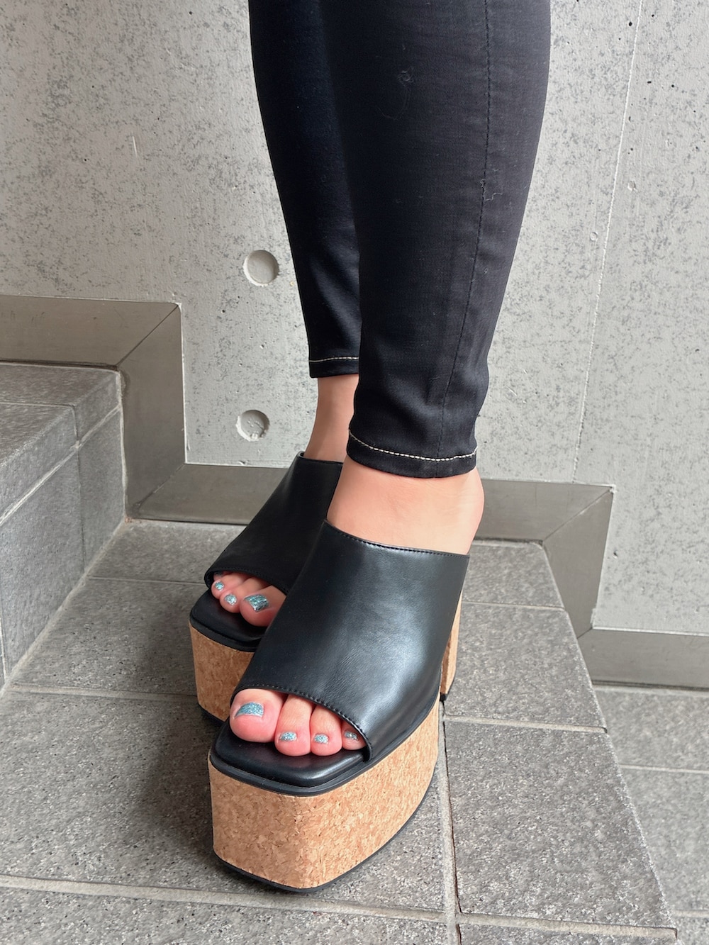 ホワイト系のキャミソール、ブラック系のデニムパンツ、ブラック系のサンダルを着用したレディースの夏コーディネートの7枚目の写真