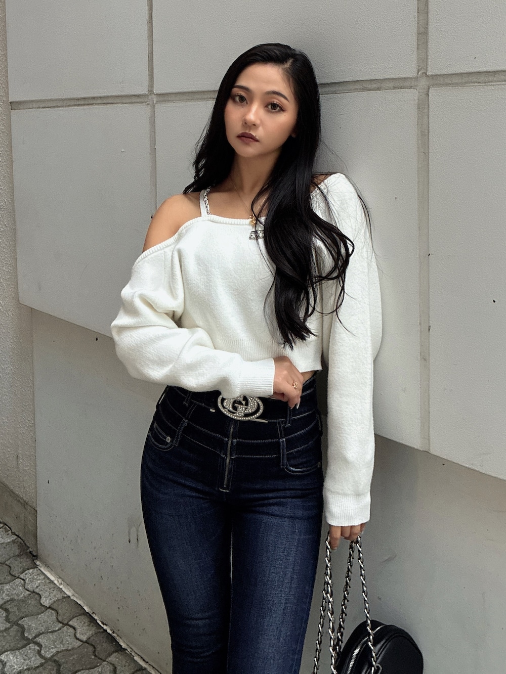 ホワイト系のニット/セーター、ブルー系のデニムパンツ、ブラック系のブーツを着用したレディースの秋コーディネートの4枚目の写真