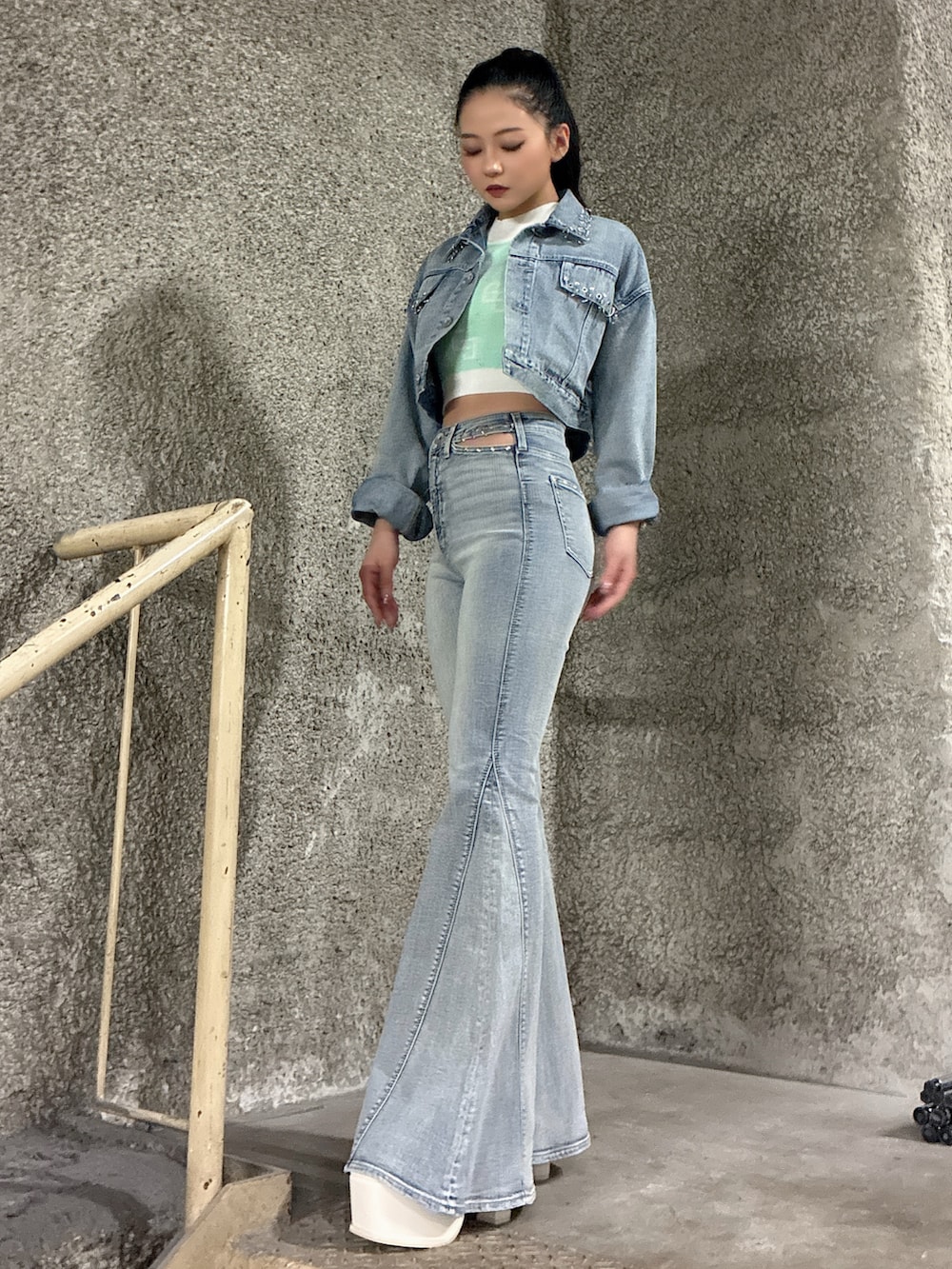 ブルー系のデニムジャケット、ブルー系のデニムパンツ、グリーン系のニット/セーターを着用したレディースの春コーディネートの2枚目の写真