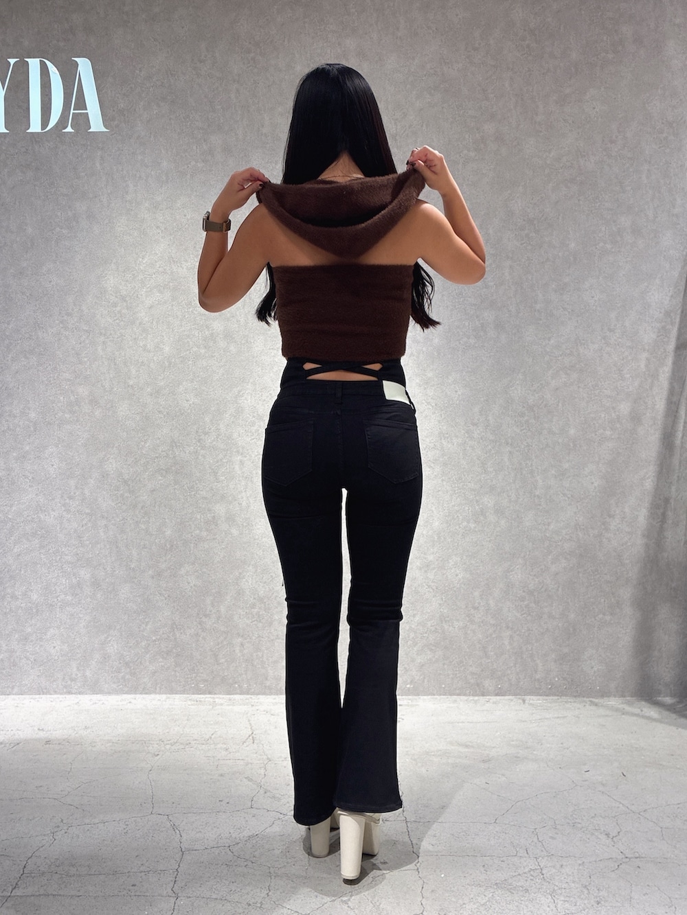 ブラウン系のニット/セーター、ブラック系のデニムパンツ、ホワイト系のブーツを着用したレディースの秋コーディネートの3枚目の写真