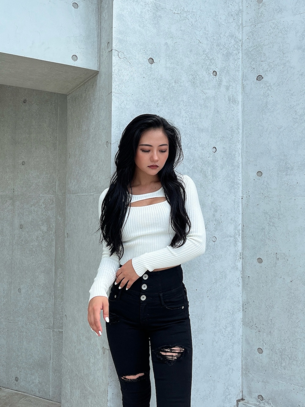 ホワイト系のニット/セーター、ブラック系のデニムパンツ、ブラック系のパンプスを着用したレディースの秋コーディネートの3枚目の写真