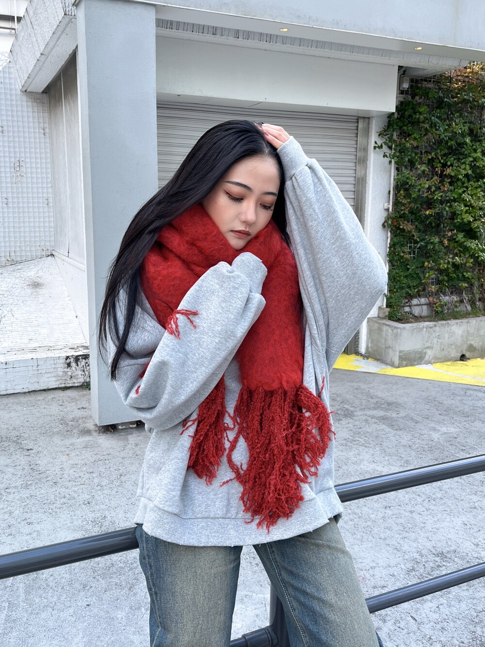 グレー系のスウェット、ブルー系のデニムパンツ、ベージュ系のブーツを着用したレディースの冬コーディネートの2枚目の写真