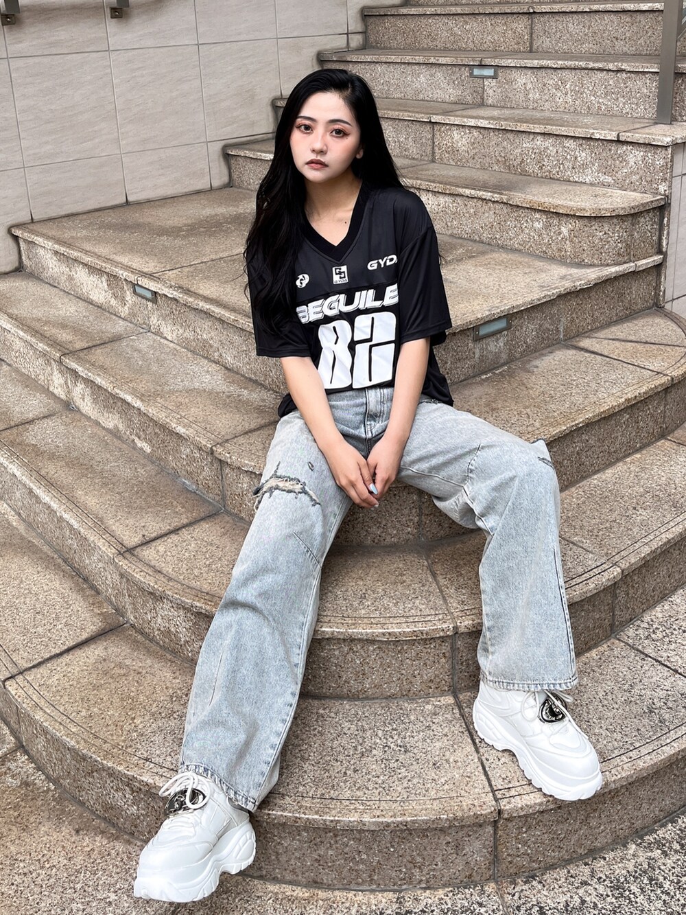 ブラック系のTシャツ/カットソー、ブルー系のデニムパンツ、ホワイト系のスニーカーを着用したレディースの夏コーディネートの2枚目の写真