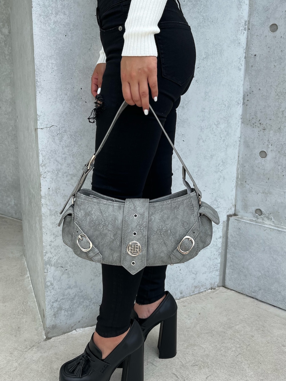 ホワイト系のニット/セーター、ブラック系のデニムパンツ、ブラック系のパンプスを着用したレディースの秋コーディネートの4枚目の写真