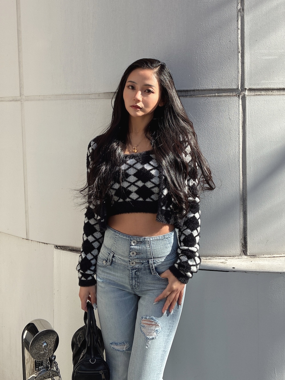 ブラック系のカーディガン/ボレロ、ブラック系のキャミソール、ブラック系のブーツを着用したレディースの冬コーディネートの3枚目の写真