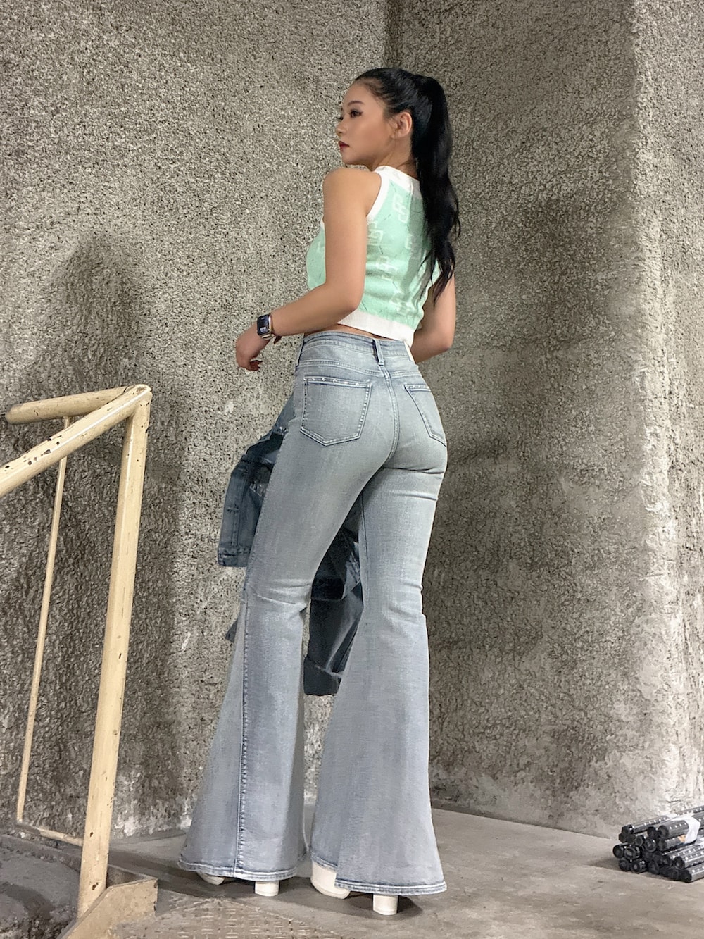 ブルー系のデニムジャケット、ブルー系のデニムパンツ、グリーン系のニット/セーターを着用したレディースの春コーディネートの3枚目の写真