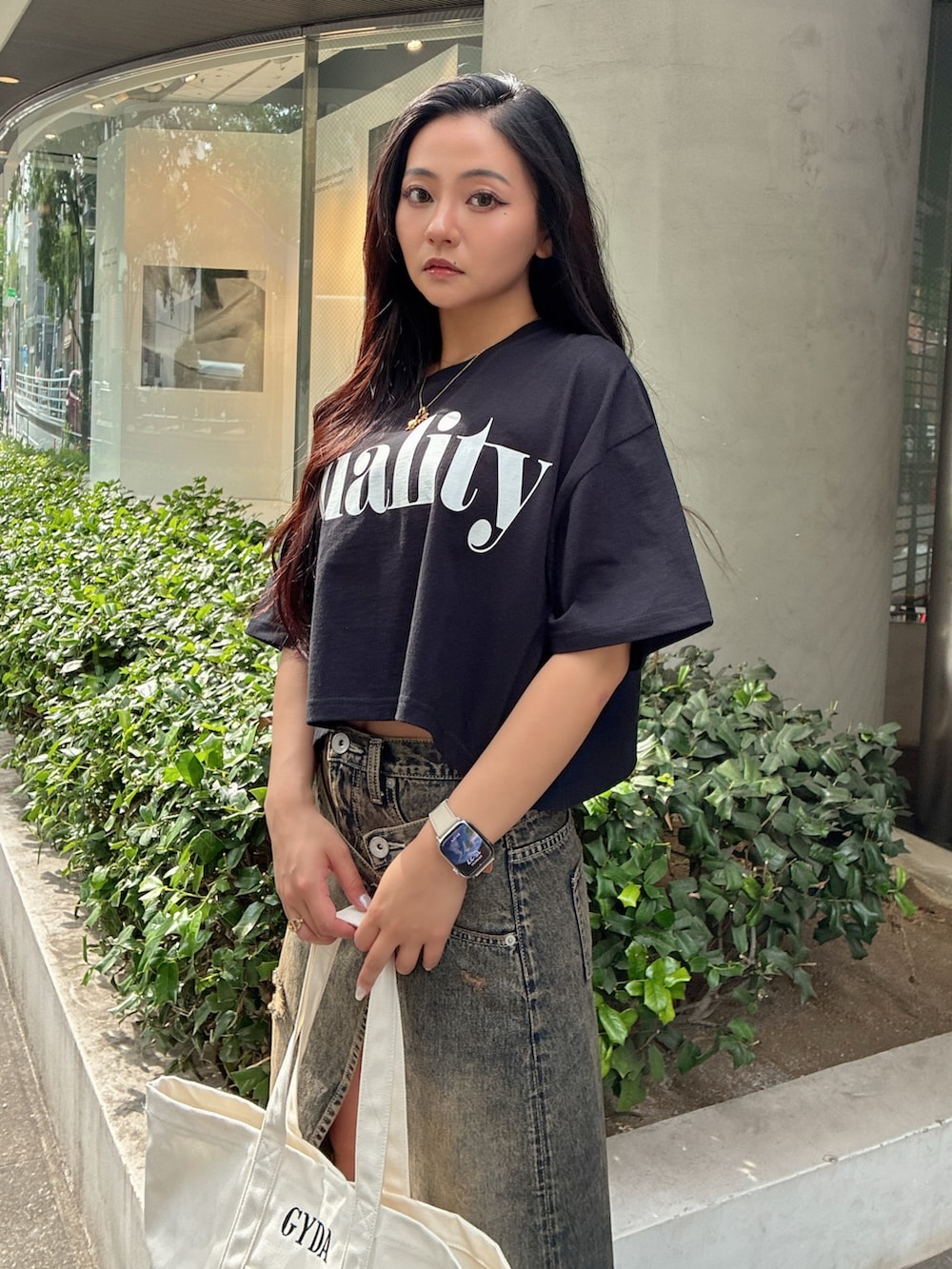ブラック系のTシャツ/カットソー、ブルー系のデニムスカート、ブラック系のサンダルを着用したレディースの夏コーディネートの4枚目の写真