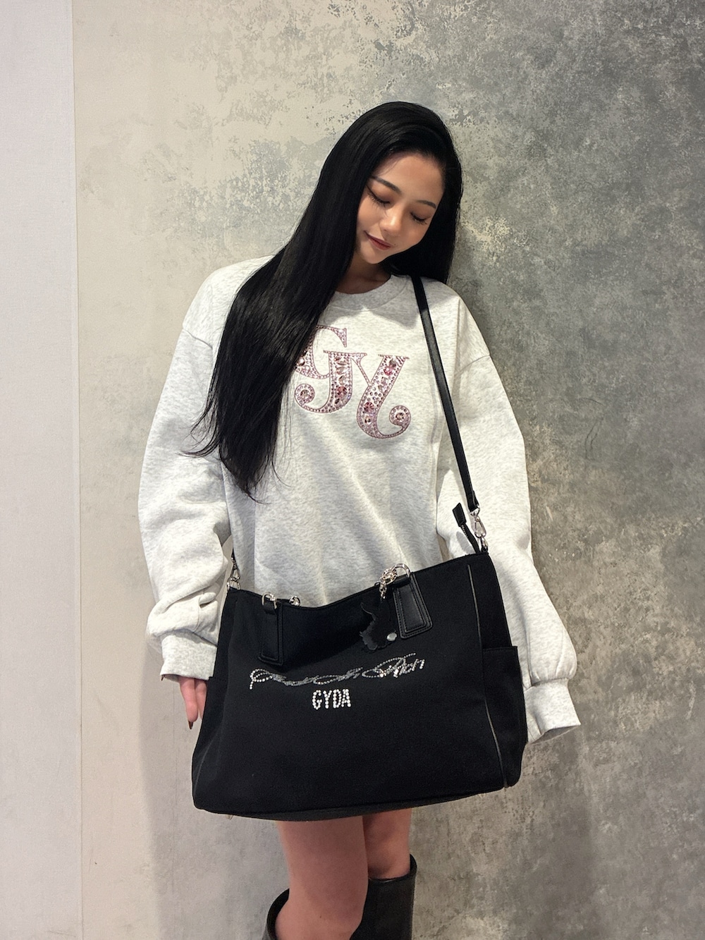 ホワイト系のスウェット、ブラック系のブーツを着用したレディースの冬コーディネートの2枚目の写真