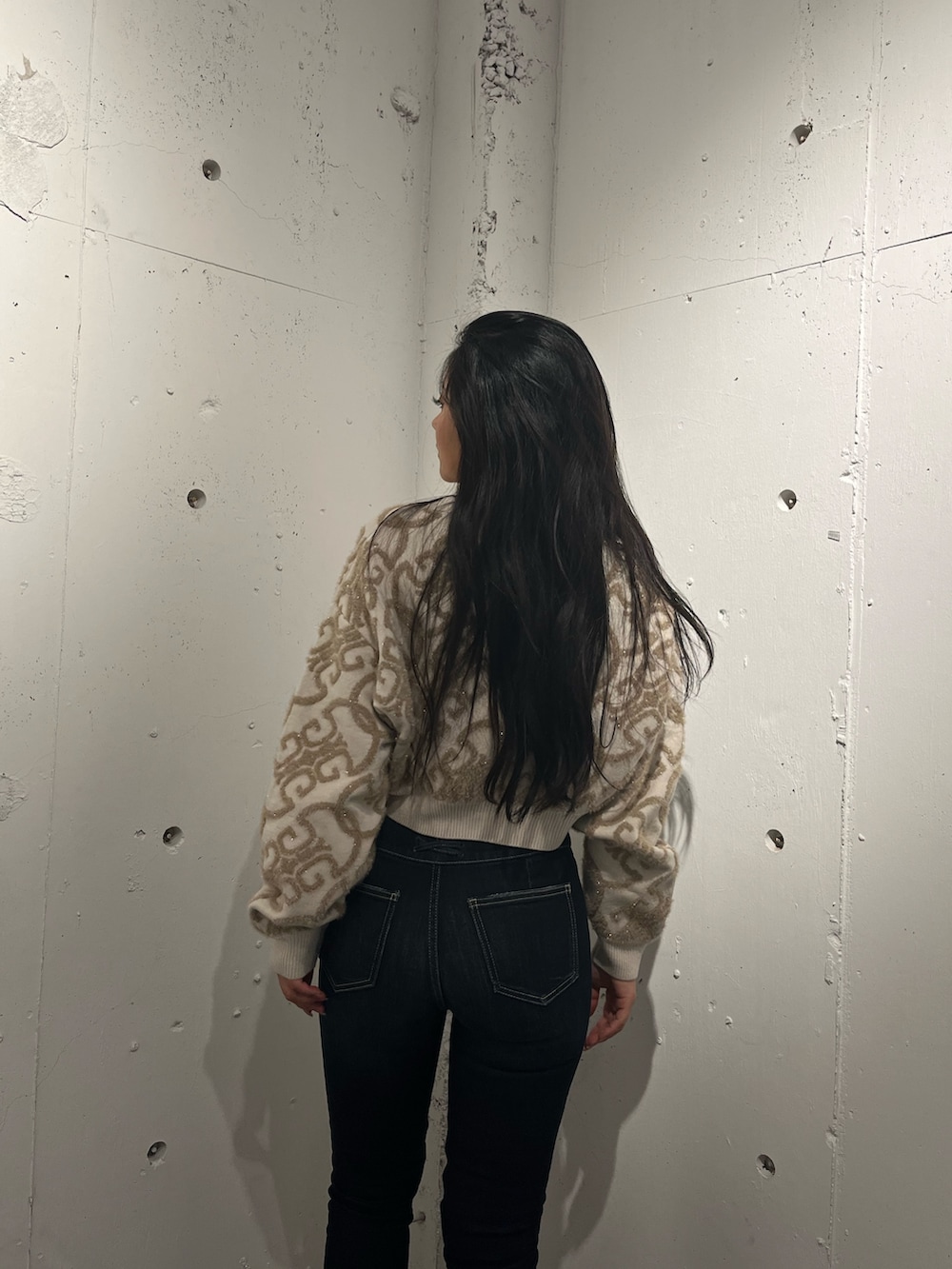 ホワイト系のニット/セーター、ブラウン系のブーツ、ブルー系のデニムパンツを着用したレディースの秋コーディネートの3枚目の写真