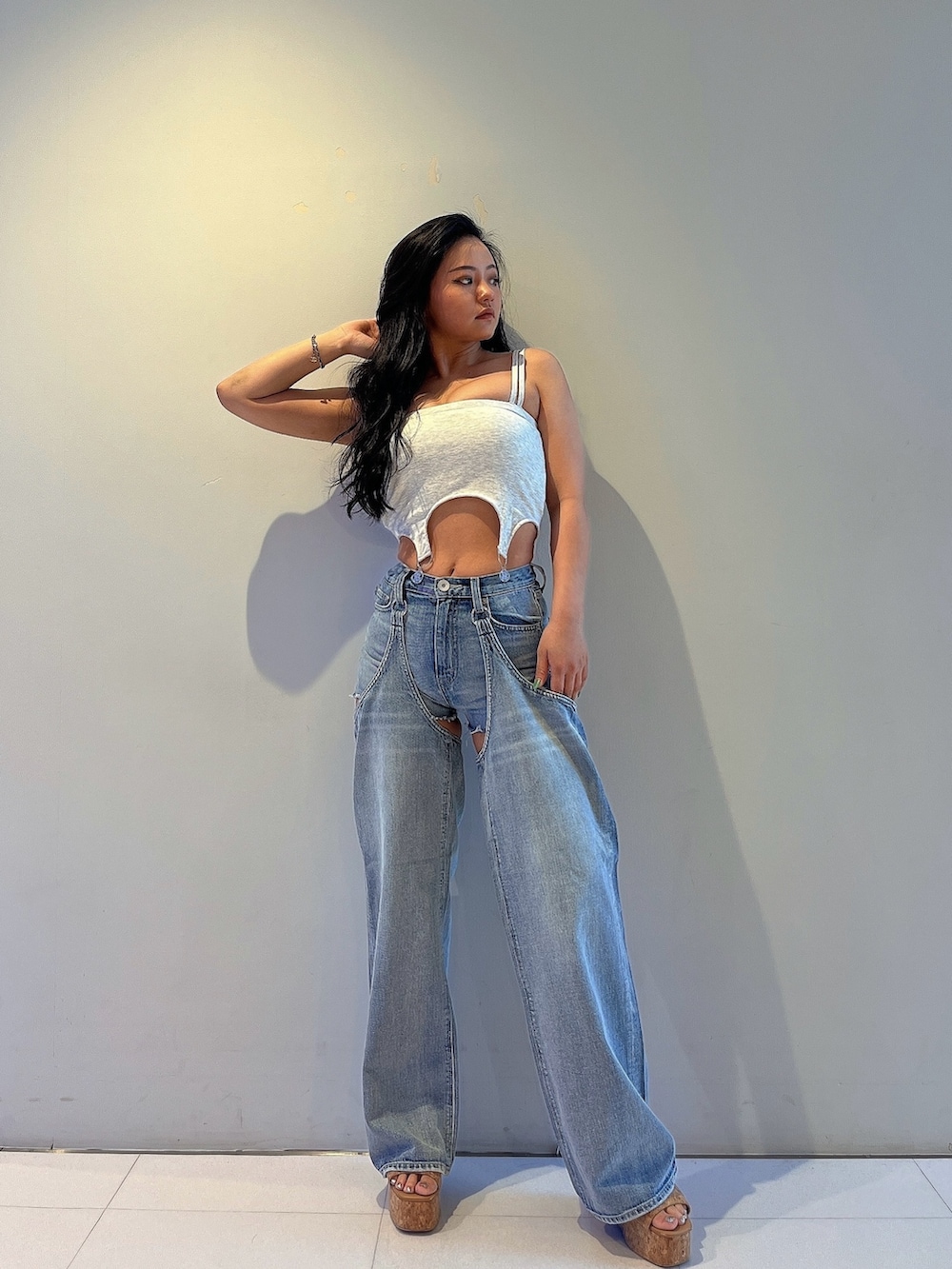 ブラック系のキャミソール、ブルー系のデニムパンツ、ベージュ系のサンダルを着用したレディースの夏コーディネートの2枚目の写真