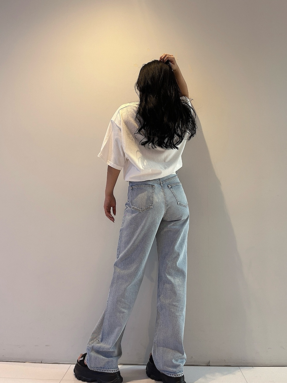 ホワイト系のTシャツ/カットソー、ブルー系のデニムパンツ、ブラック系のサンダルを着用したレディースの春コーディネートの3枚目の写真