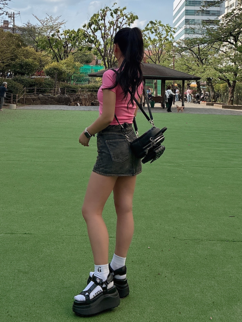 ピンク系のTシャツ/カットソー、ブルー系のデニムスカート、ブラック系のバックパック/リュックを着用したレディースの春コーディネートの3枚目の写真