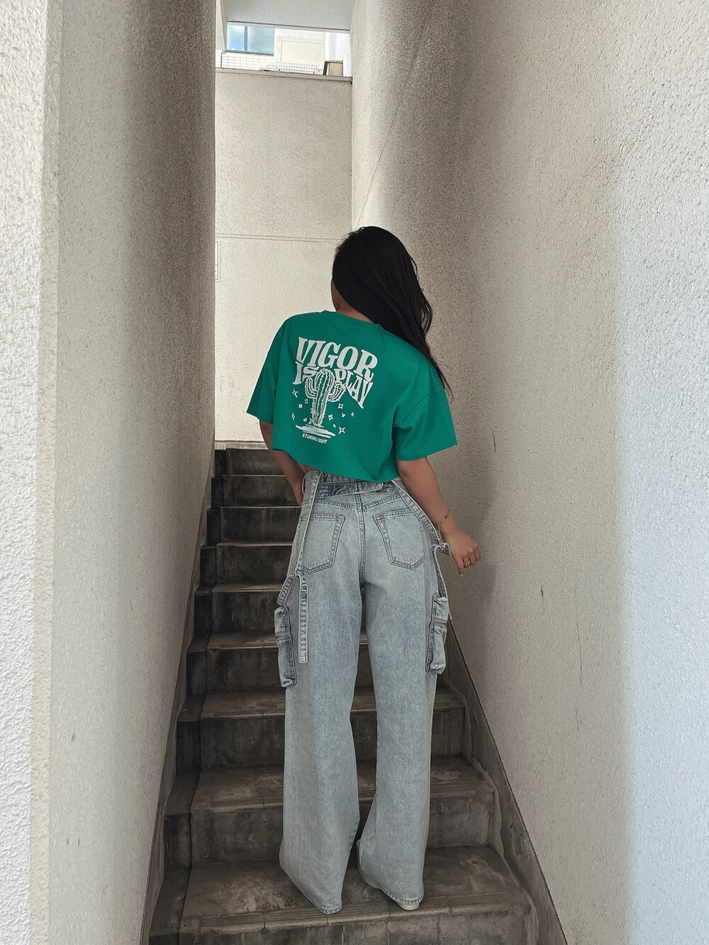 グリーン系のTシャツ/カットソー、ブルー系のデニムパンツ、ホワイト系のサンダルを着用したレディースの夏コーディネートの2枚目の写真
