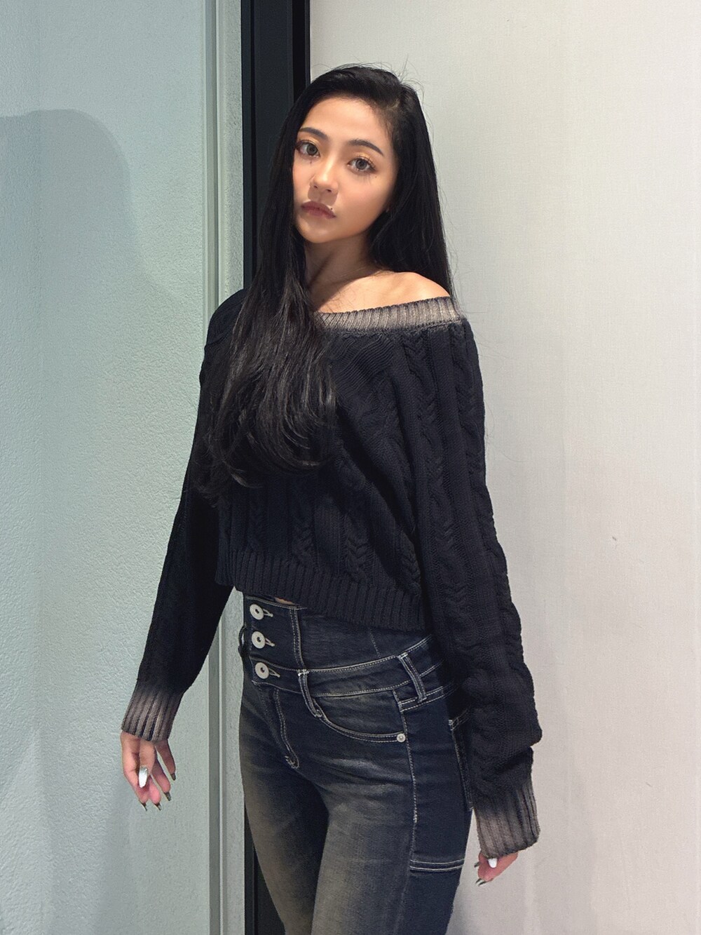 ブラック系のニット/セーター、ブルー系のデニムパンツ、ブラック系のブーツを着用したレディースの秋コーディネートの3枚目の写真