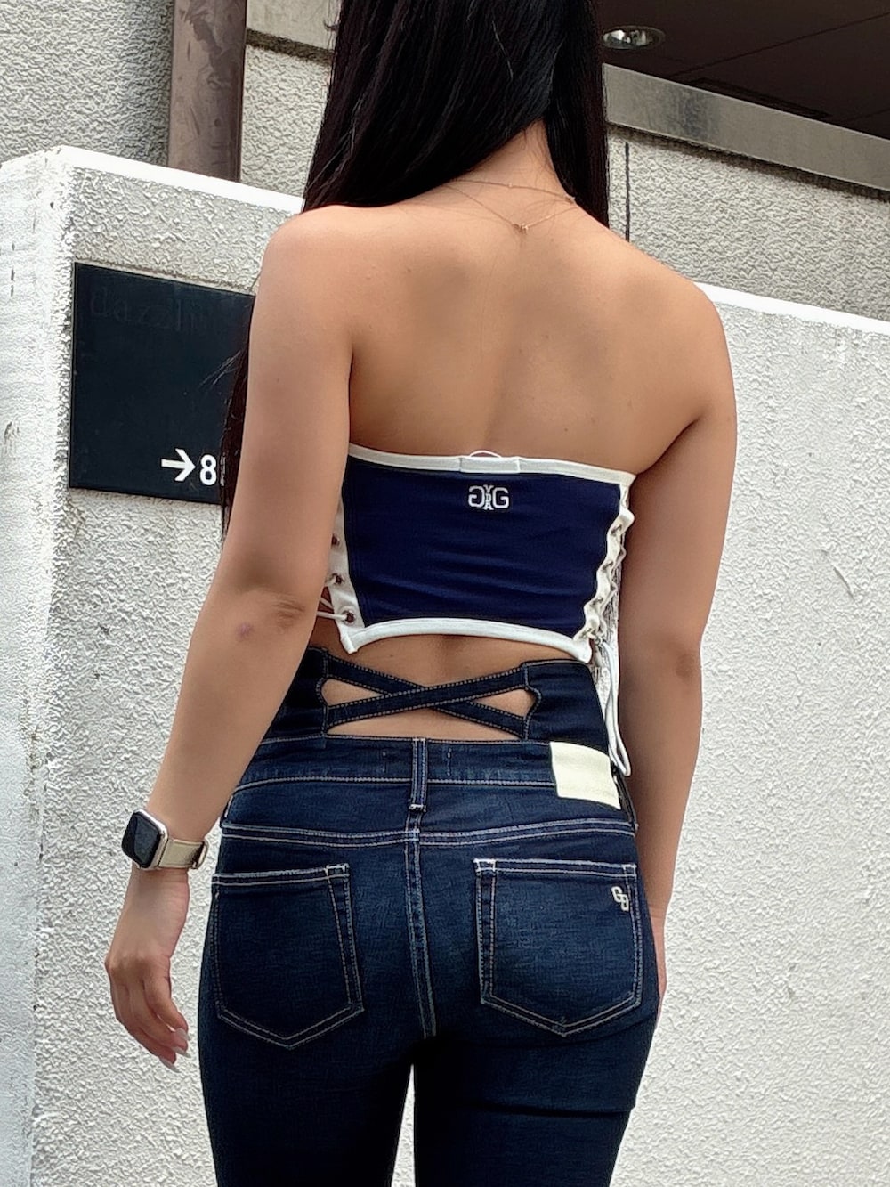 ブルー系のチューブトップ、ブルー系のデニムパンツ、ブラック系のサンダルを着用したレディースの夏コーディネートの4枚目の写真