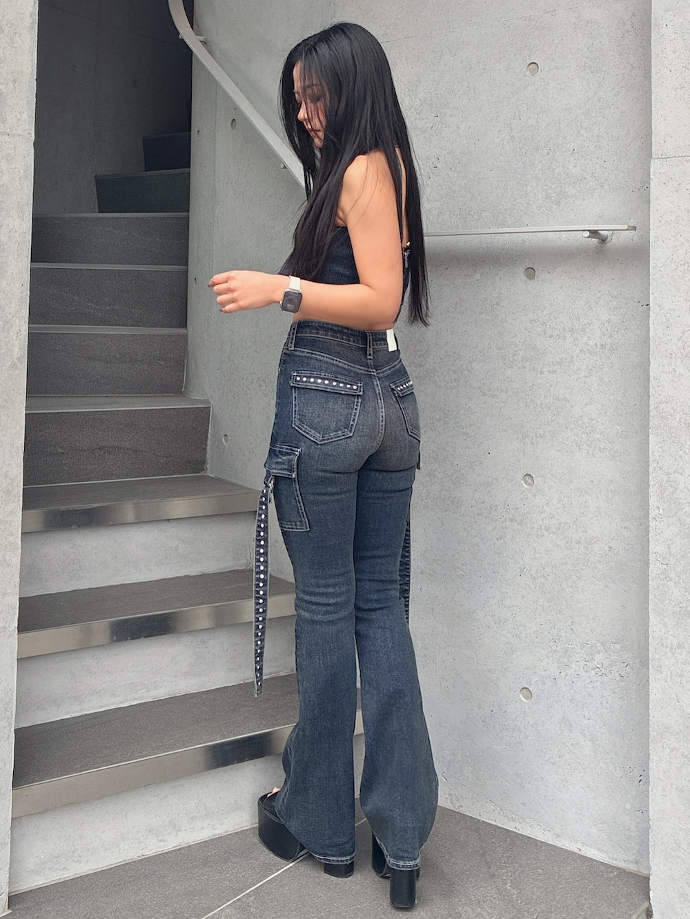 ブルー系のタンクトップ、ブルー系のデニムパンツ、ブラック系のサンダルを着用したレディースの春コーディネートの3枚目の写真