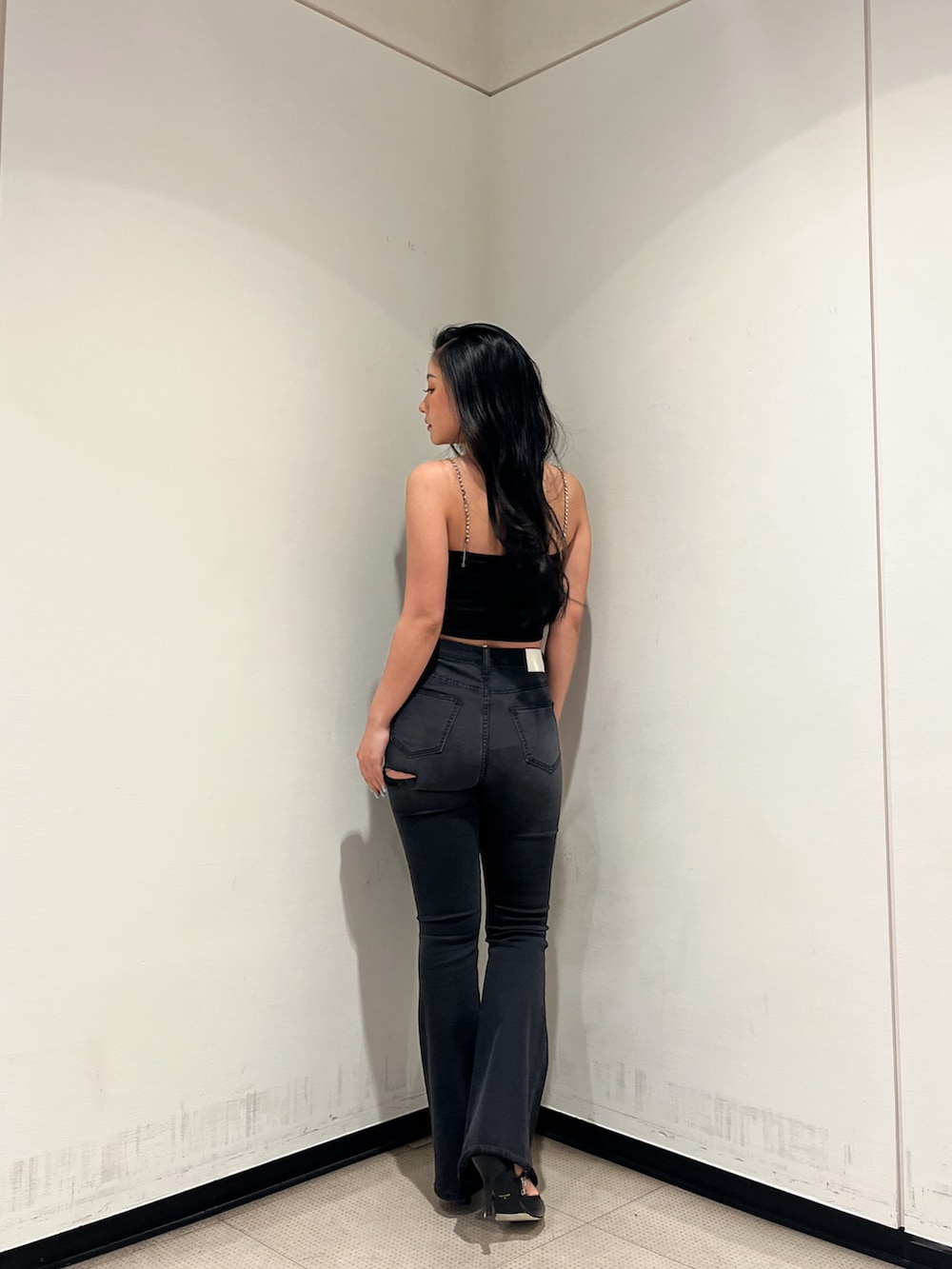 ブラック系のデニムパンツ、ブラック系のキャミソール、ブラック系のパンプスを着用したレディースの冬コーディネートの2枚目の写真