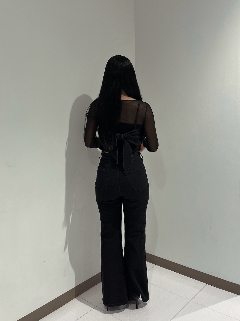 ブラック系のニット/セーター、ブラック系のワンピース、ブラック系のパンプスを着用したレディースの秋コーディネートの3枚目の写真