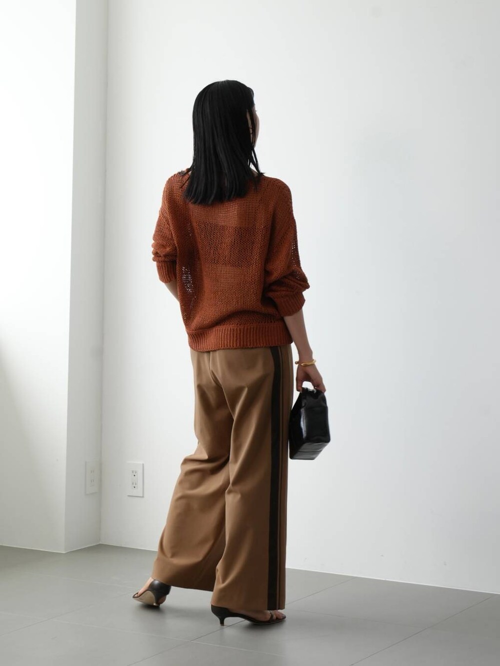 イエロー系のニット/セーター、ブラウン系のサンダル、ベージュ系のその他パンツを着用したレディースの夏コーディネートの3枚目の写真