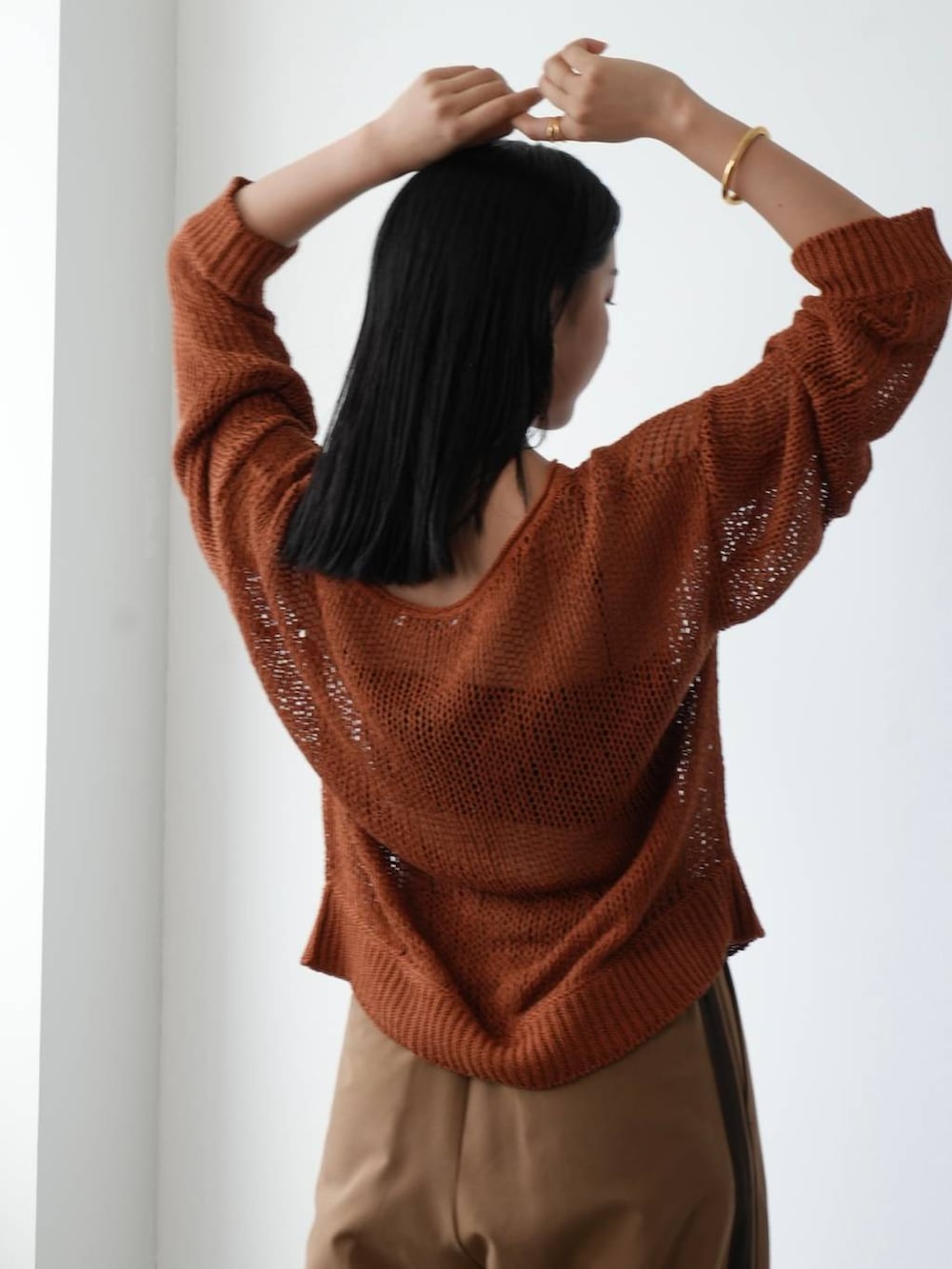 イエロー系のニット/セーター、ブラウン系のサンダル、ベージュ系のその他パンツを着用したレディースの夏コーディネートの6枚目の写真