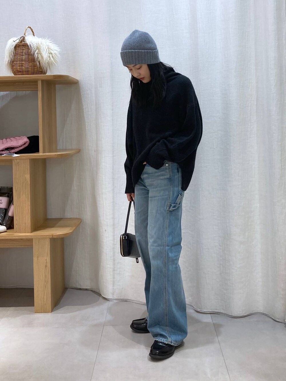 グレー系のニット/セーター、ブルー系のデニムパンツ、グレー系のニットキャップ/ビーニーを着用したレディースの冬コーディネートの3枚目の写真