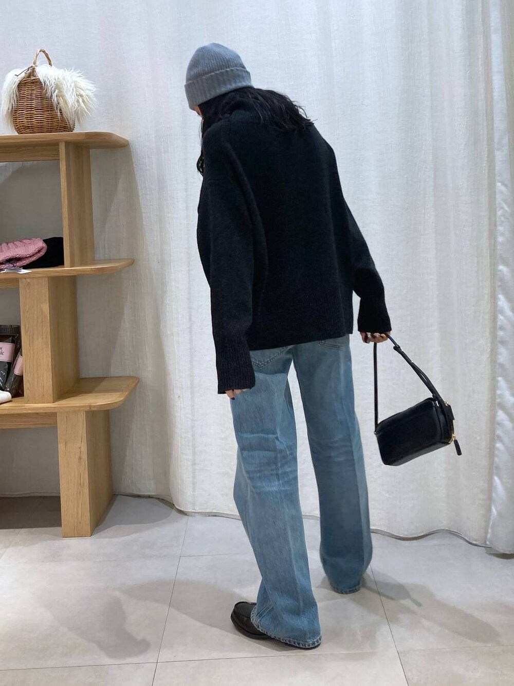 グレー系のニット/セーター、ブルー系のデニムパンツ、グレー系のニットキャップ/ビーニーを着用したレディースの冬コーディネートの5枚目の写真