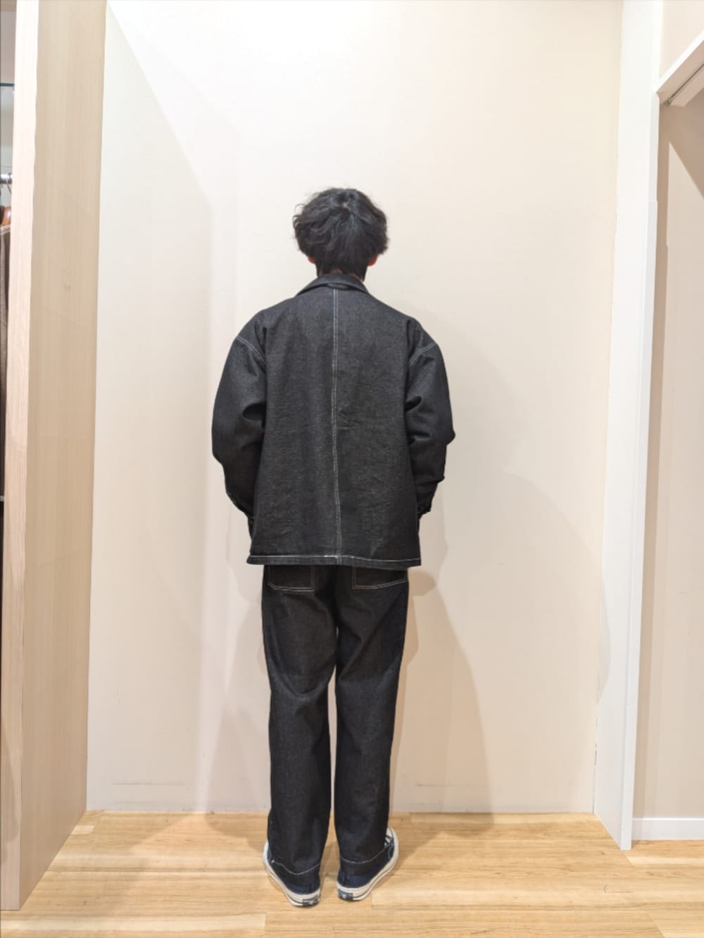 ブラック系のカバーオール、ブルー系のデニムパンツ、その他のスウェットを着用したメンズの冬コーディネートの3枚目の写真