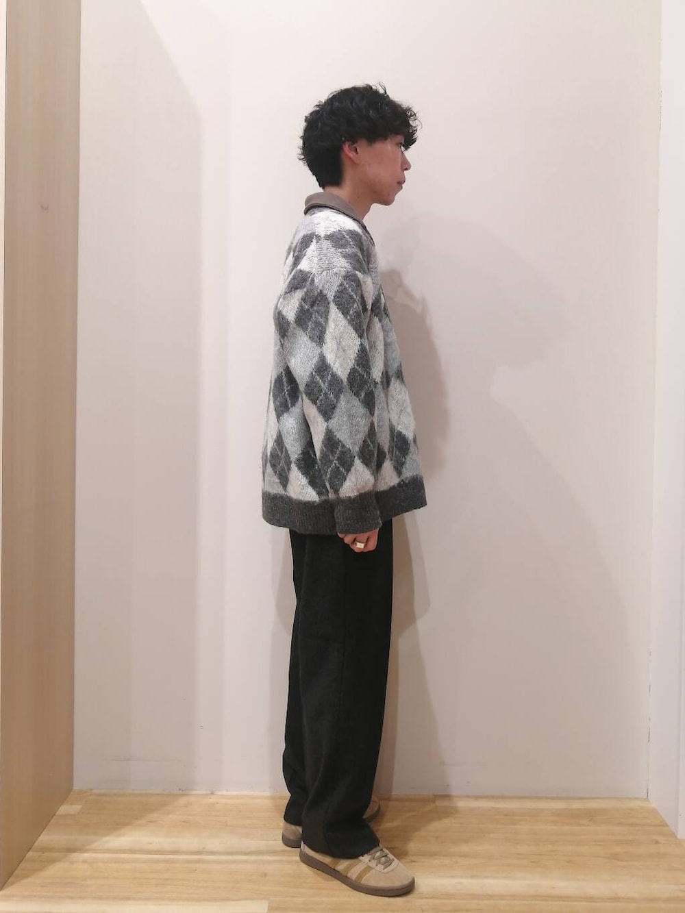 グレー系のニット/セーター、ブラウン系のTシャツ/カットソー、ブラック系のその他パンツを着用したメンズの冬コーディネートの4枚目の写真