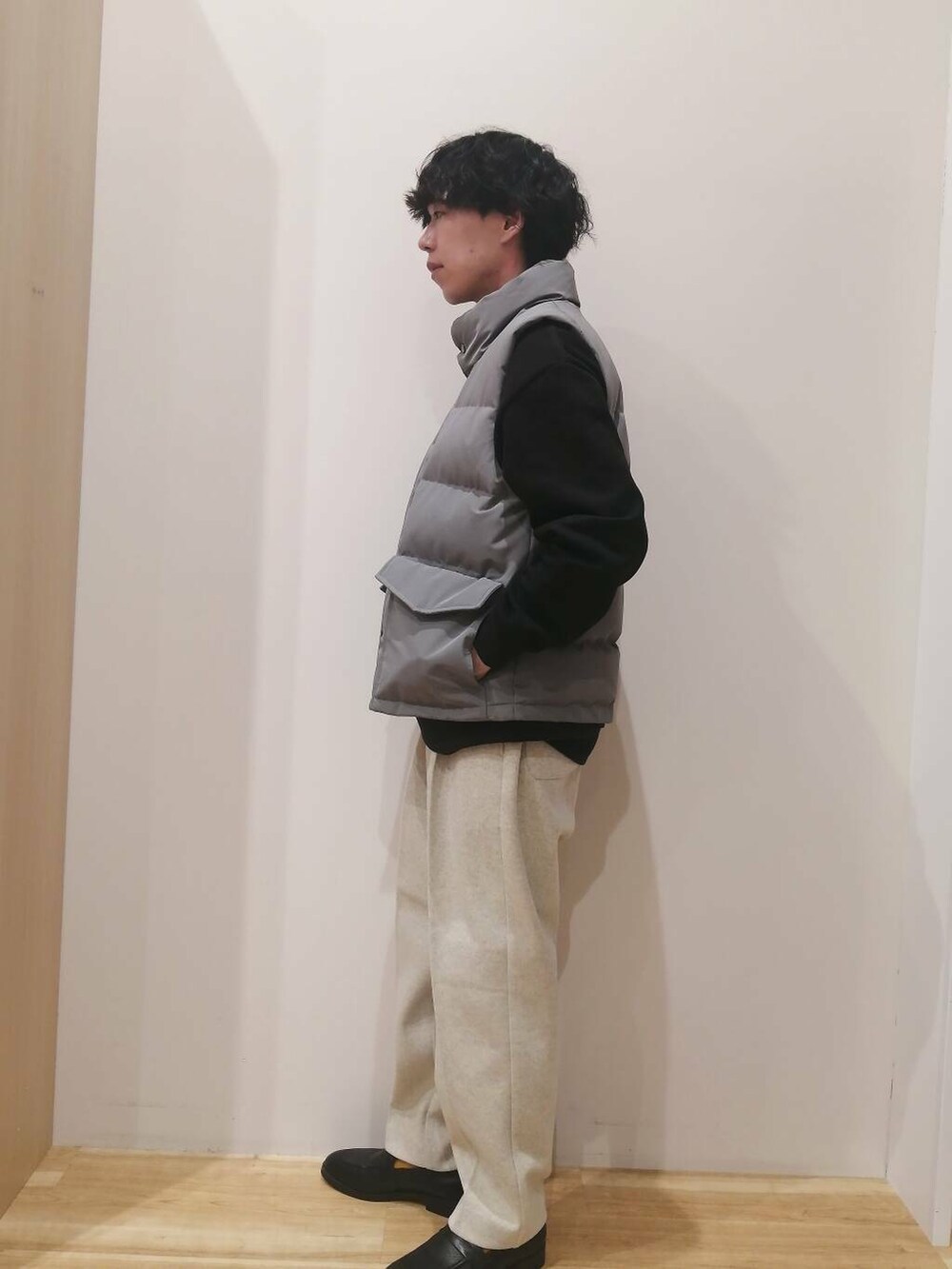 グレー系のダウンベスト、ベージュ系のその他パンツ、ブラック系のスウェットを着用したメンズの冬コーディネートの2枚目の写真