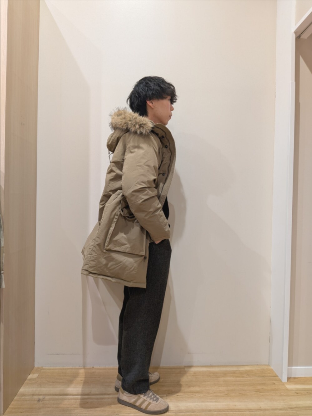 ベージュ系のダウンジャケット/コート、ブラック系のニット/セーター、グレー系のその他パンツを着用したメンズの冬コーディネートの4枚目の写真