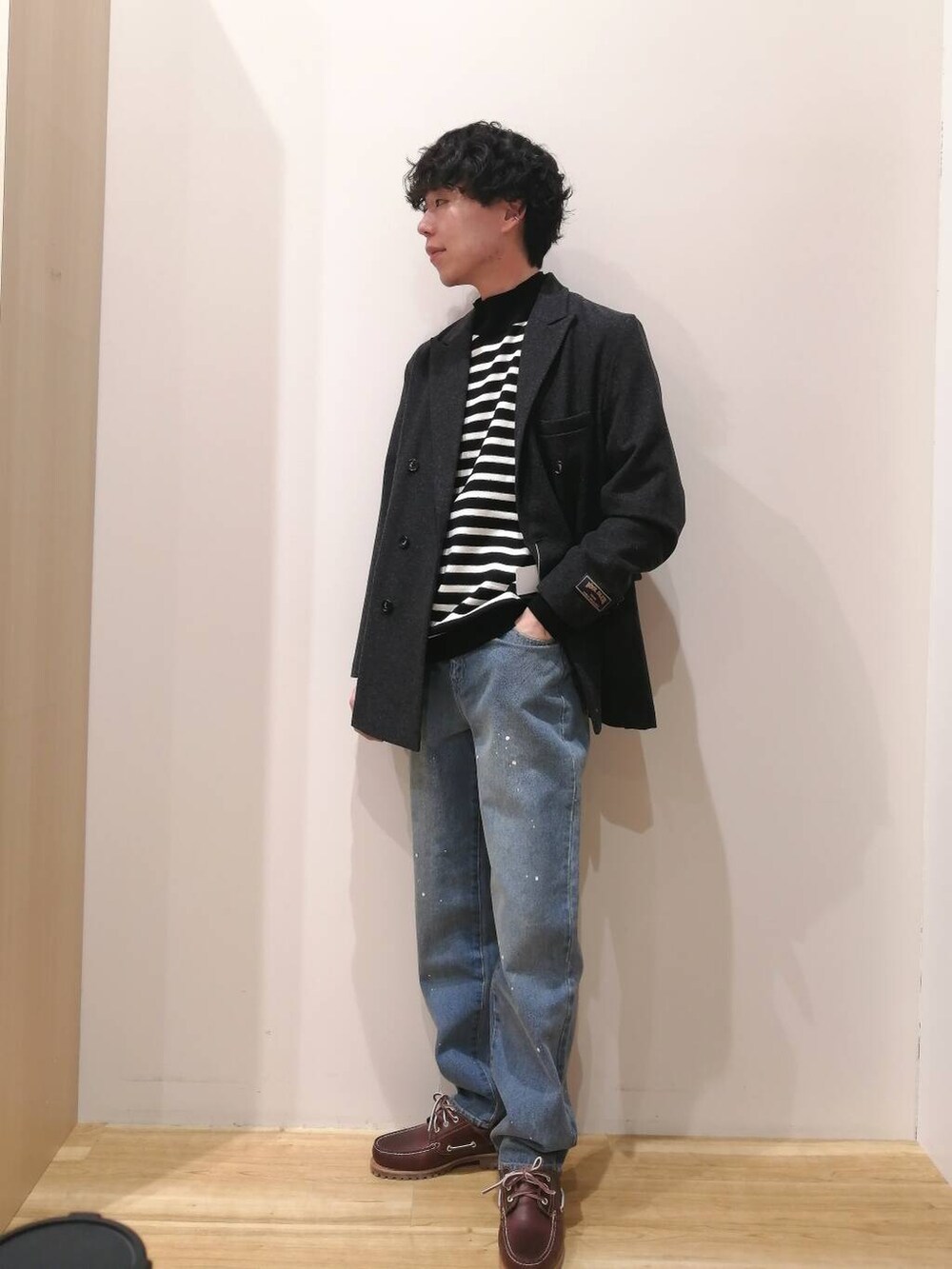 ブラック系のニット/セーター、ブラック系のその他アウター、ブルー系のデニムパンツを着用したメンズの冬コーディネートの4枚目の写真