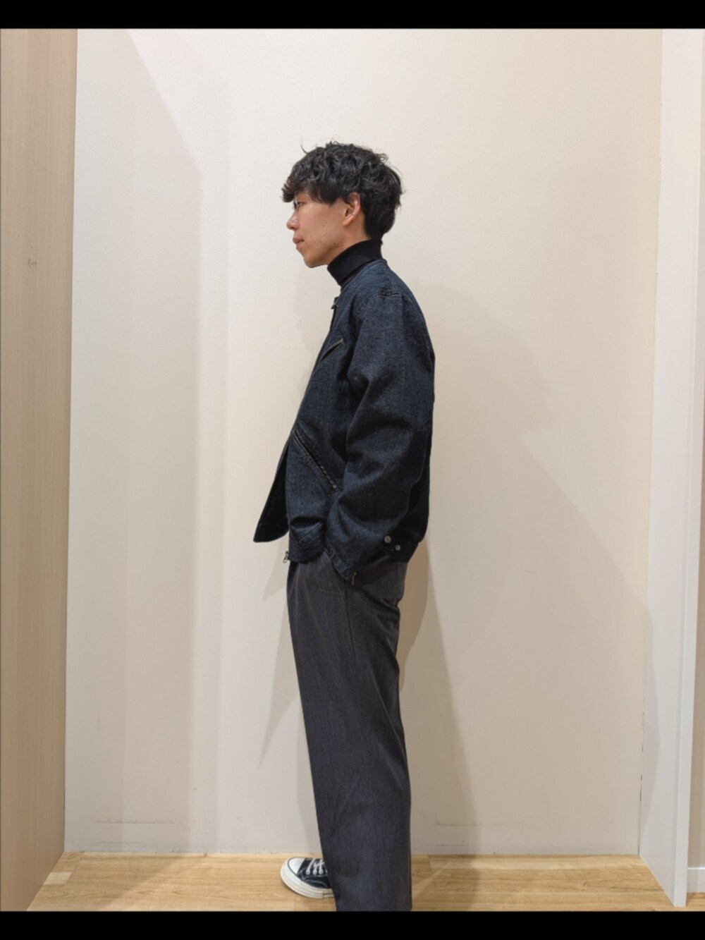 ブルー系のデニムジャケット、ブラック系のニット/セーター、グレー系のその他パンツを着用したメンズの秋コーディネートの2枚目の写真