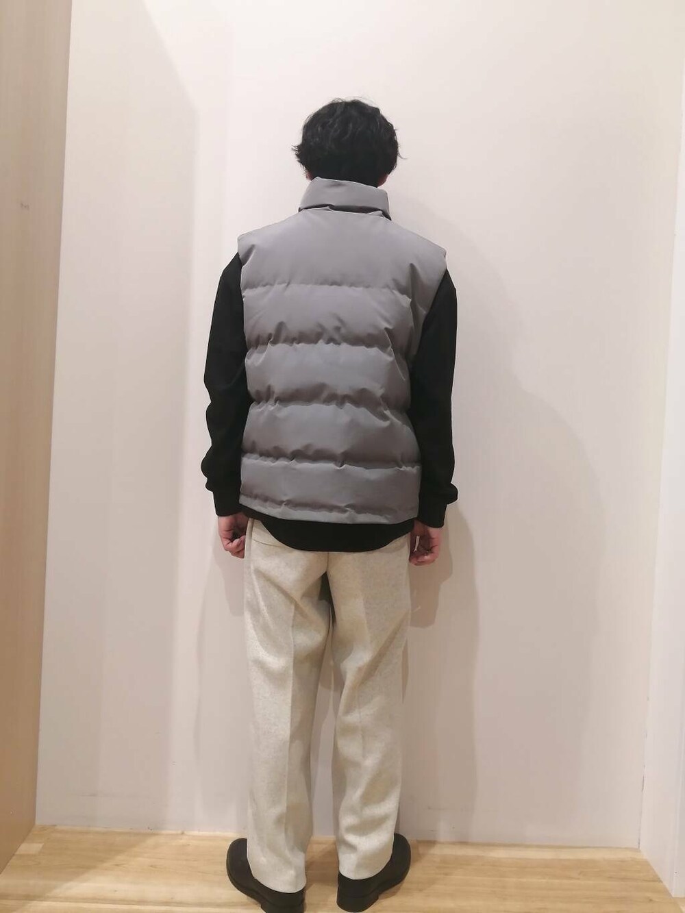 グレー系のダウンベスト、ベージュ系のその他パンツ、ブラック系のスウェットを着用したメンズの冬コーディネートの4枚目の写真