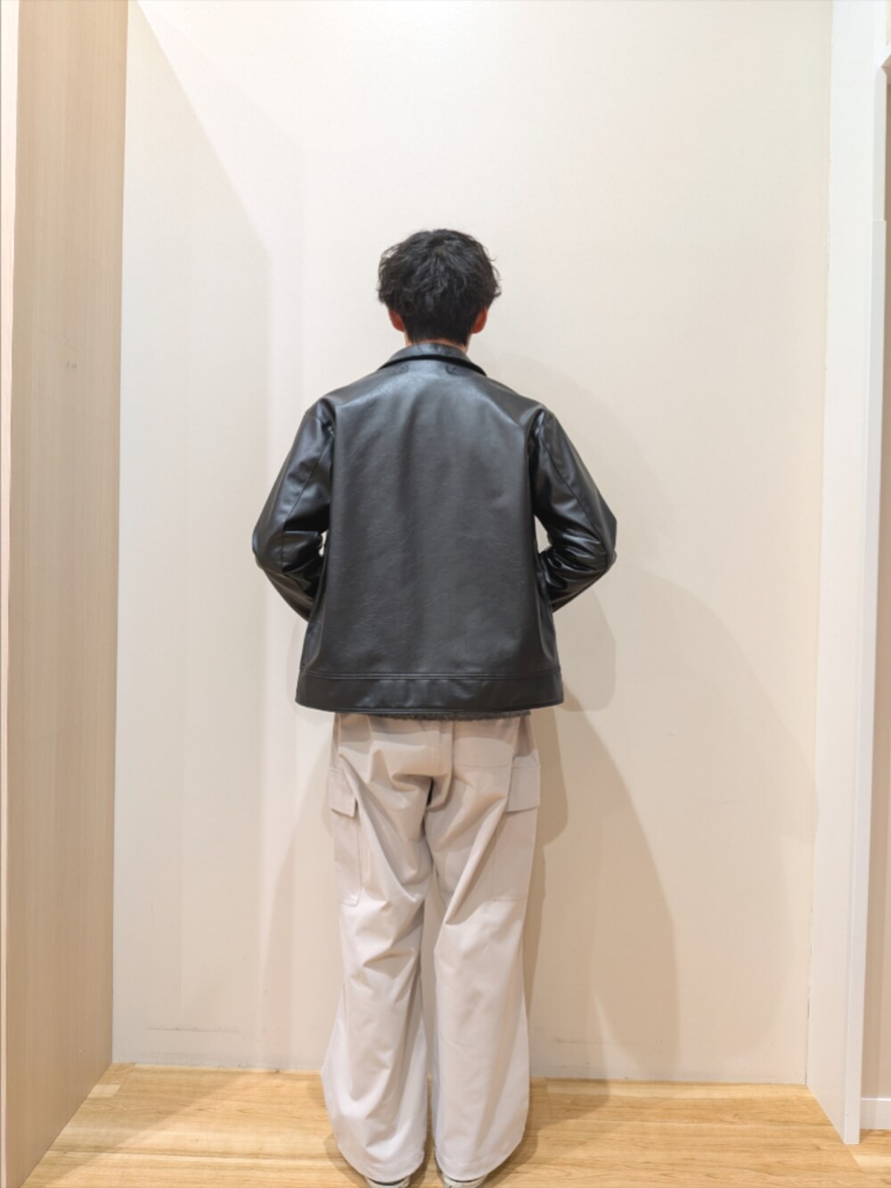 ブラック系のその他アウター、ブラック系のニット/セーター、ベージュ系のその他パンツを着用したメンズの冬コーディネートの3枚目の写真