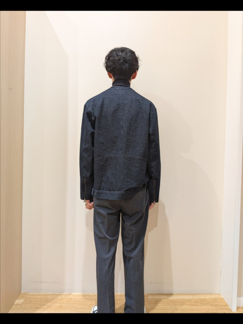 ブルー系のデニムジャケット、ブラック系のニット/セーター、グレー系のその他パンツを着用したメンズの秋コーディネートの3枚目の写真