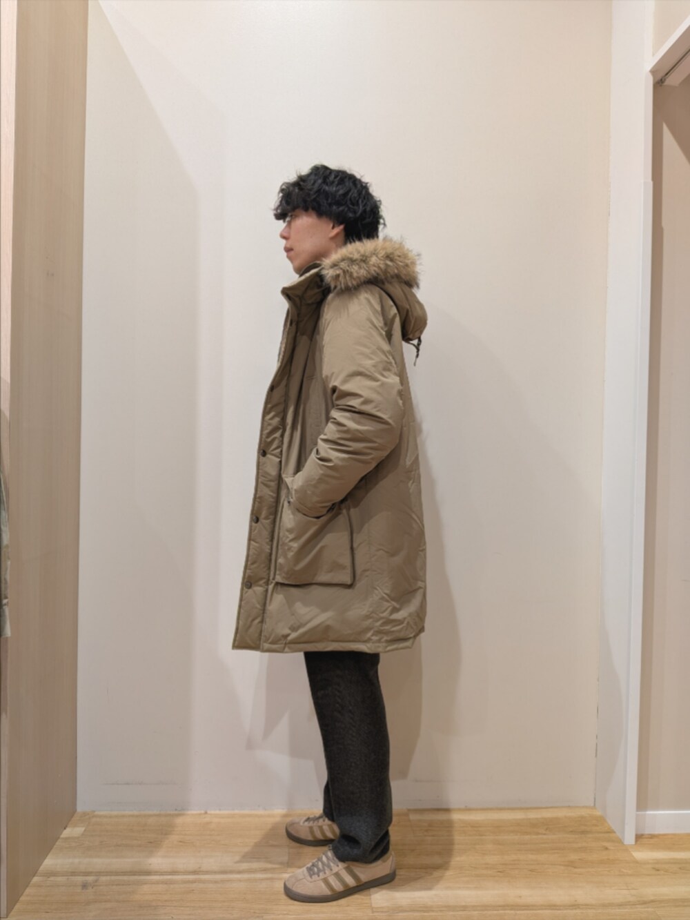 ベージュ系のダウンジャケット/コート、ブラック系のニット/セーター、グレー系のその他パンツを着用したメンズの冬コーディネートの2枚目の写真