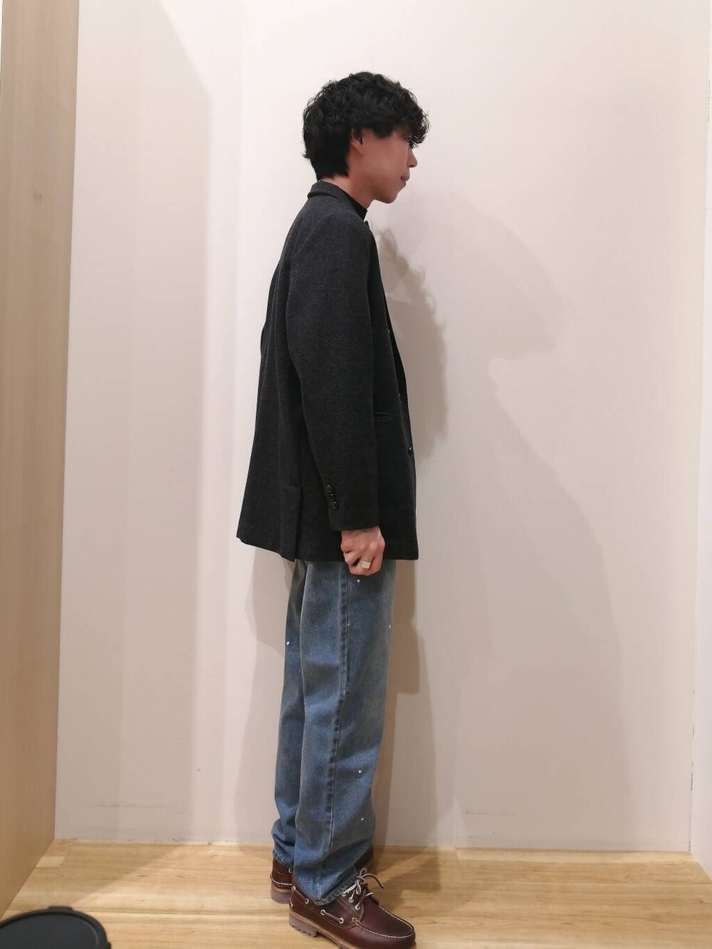 ブラック系のニット/セーター、ブラック系のその他アウター、ブルー系のデニムパンツを着用したメンズの冬コーディネートの2枚目の写真