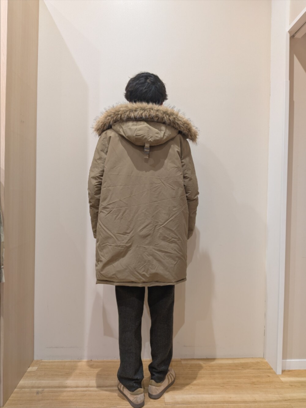 ベージュ系のダウンジャケット/コート、ブラック系のニット/セーター、グレー系のその他パンツを着用したメンズの冬コーディネートの3枚目の写真