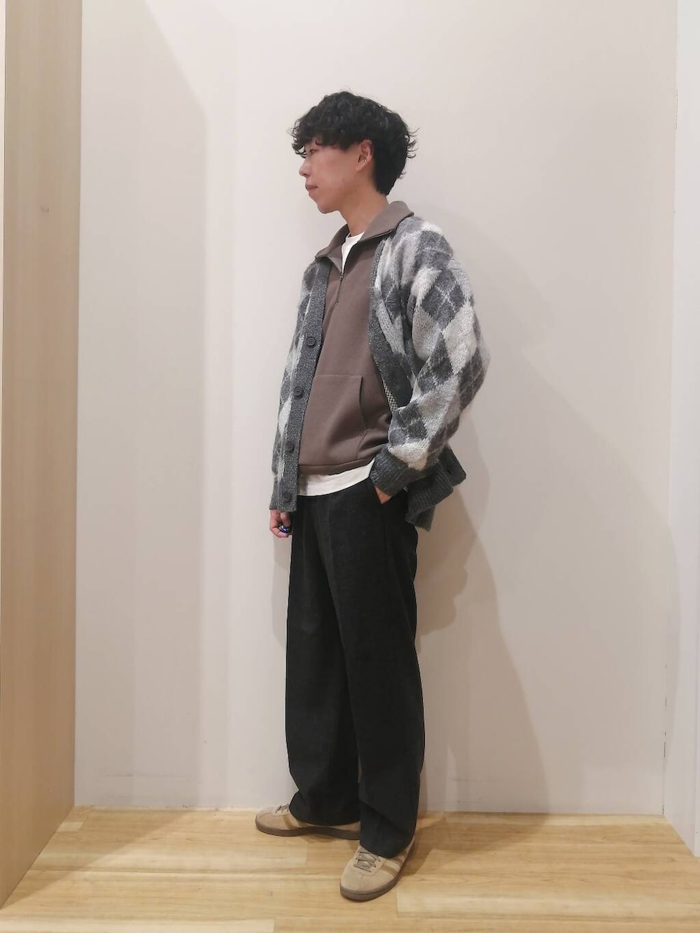 グレー系のニット/セーター、ブラウン系のTシャツ/カットソー、ブラック系のその他パンツを着用したメンズの冬コーディネートの2枚目の写真