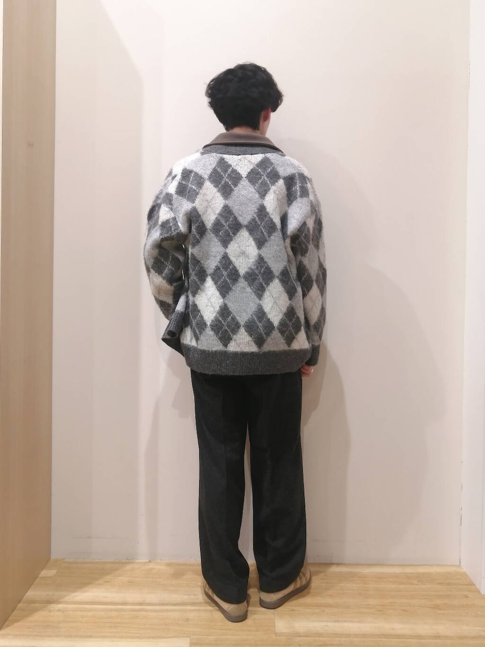 グレー系のニット/セーター、ブラウン系のTシャツ/カットソー、ブラック系のその他パンツを着用したメンズの冬コーディネートの3枚目の写真