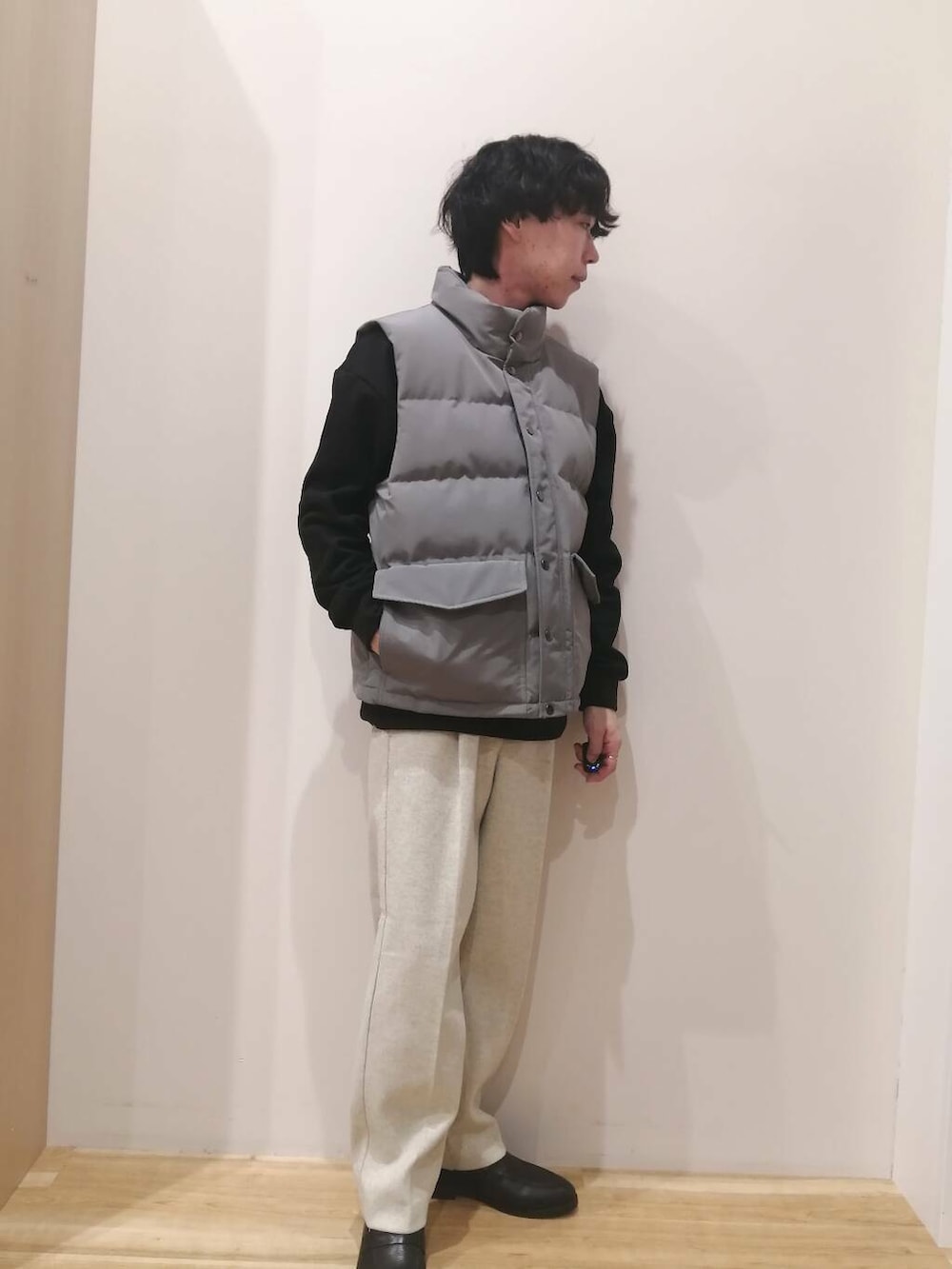 グレー系のダウンベスト、ベージュ系のその他パンツ、ブラック系のスウェットを着用したメンズの冬コーディネートの3枚目の写真