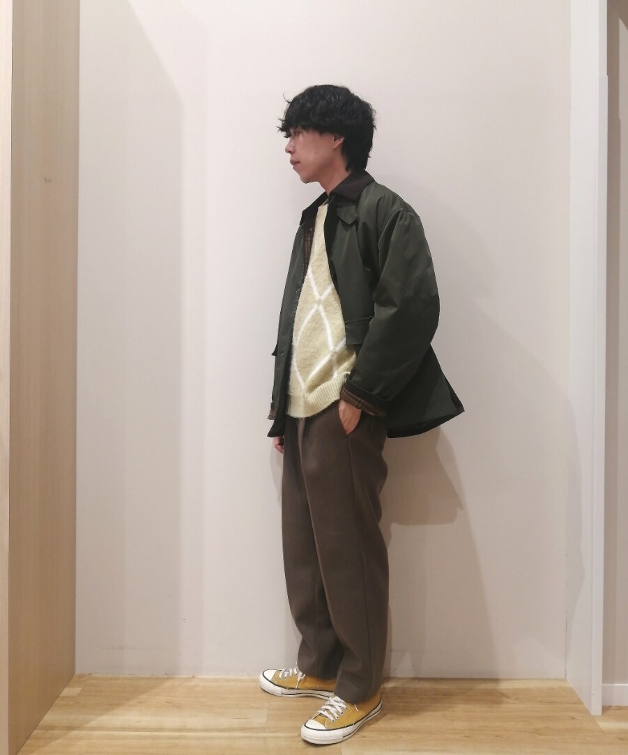 グリーン系のミリタリージャケット、イエロー系のニット/セーター、ブラウン系のその他パンツを着用したメンズの冬コーディネートの2枚目の写真