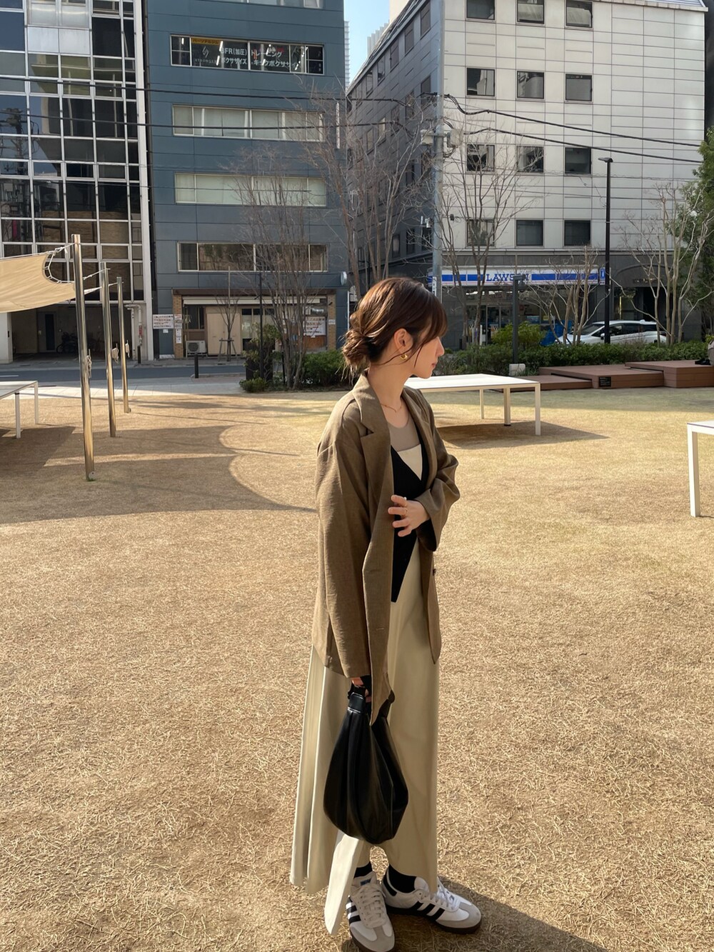 ホワイト系のスニーカーを着用したレディースの春コーディネートの2枚目の写真