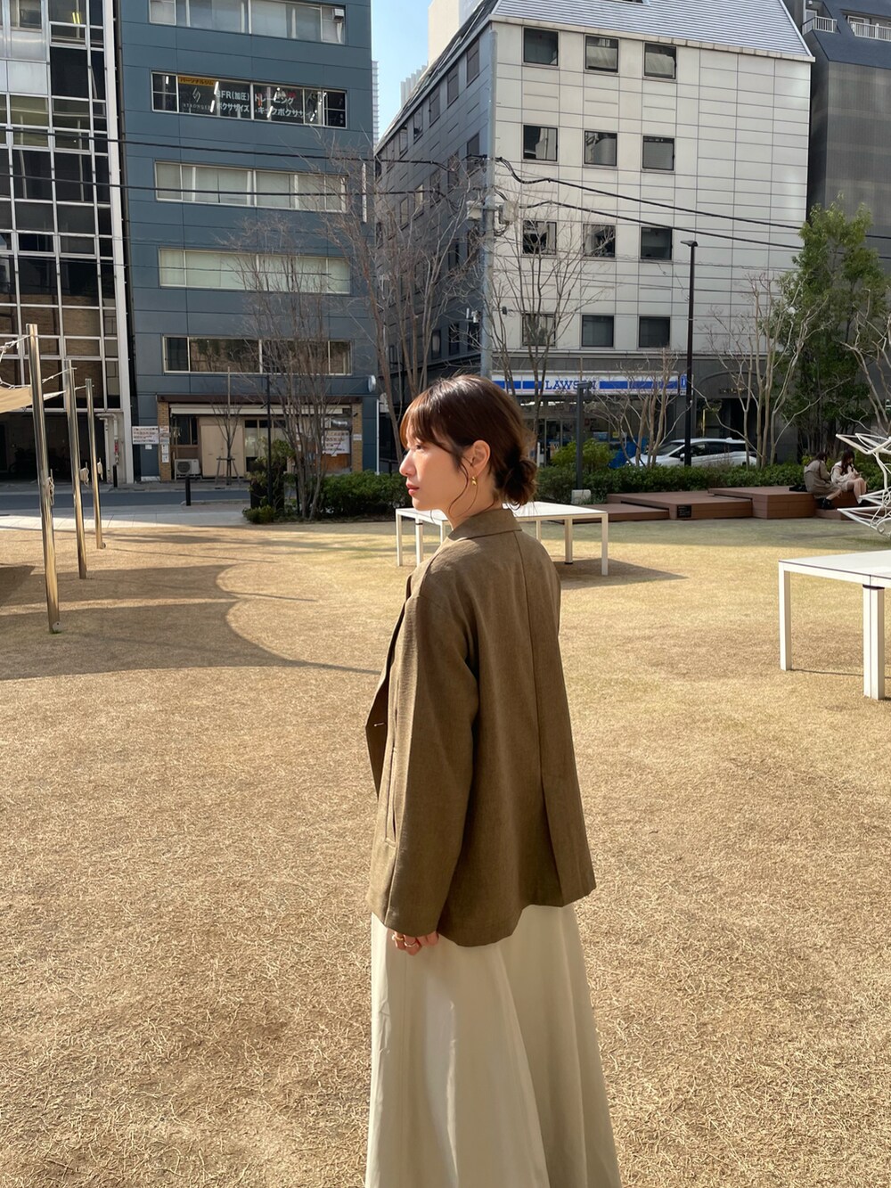 ホワイト系のスニーカーを着用したレディースの春コーディネートの3枚目の写真