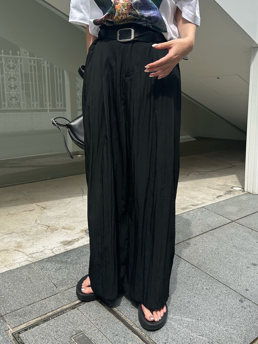 ブラック系のサンダル、ブラック系のスラックス、ブラック系のベルトを着用したレディースの夏コーディネートの3枚目の写真