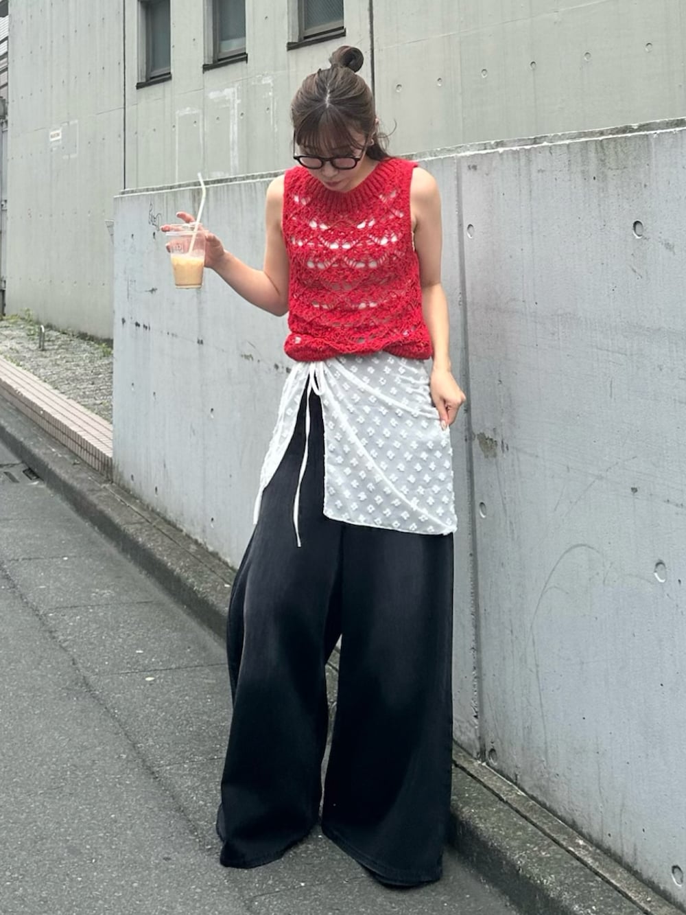 ブラック系のデニムパンツ、レッド系のニット/セーター、ブラック系のサンダルを着用したレディースの夏コーディネートの2枚目の写真