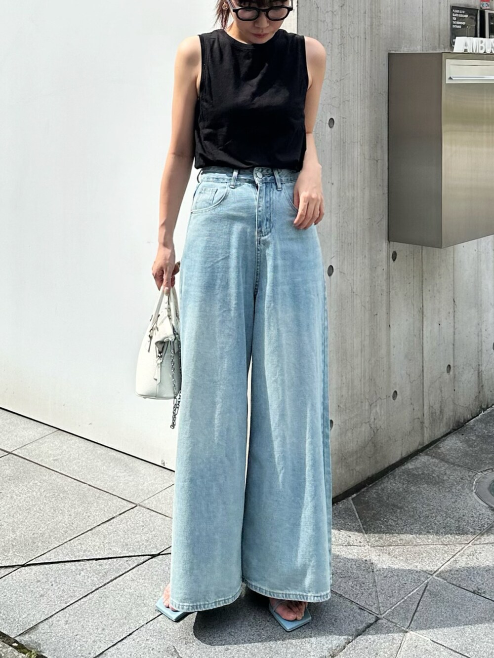 ブルー系のサンダル、ブルー系のデニムパンツ、ホワイト系のショルダーバッグを着用したレディースの春コーディネートの2枚目の写真