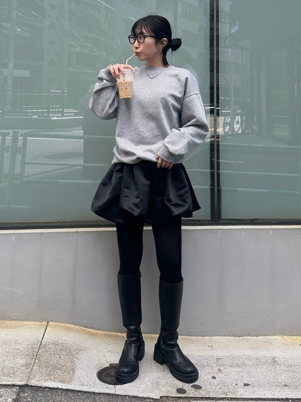 ブラック系のブーツ、ブラック系のスカート、グレー系のスウェットを着用したレディースの冬コーディネートの2枚目の写真
