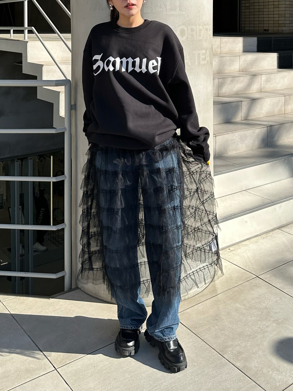 ブラック系のタンクトップ、ブラック系のローファー、シルバー系のピアス（両耳用）を着用したレディースの春コーディネートの2枚目の写真